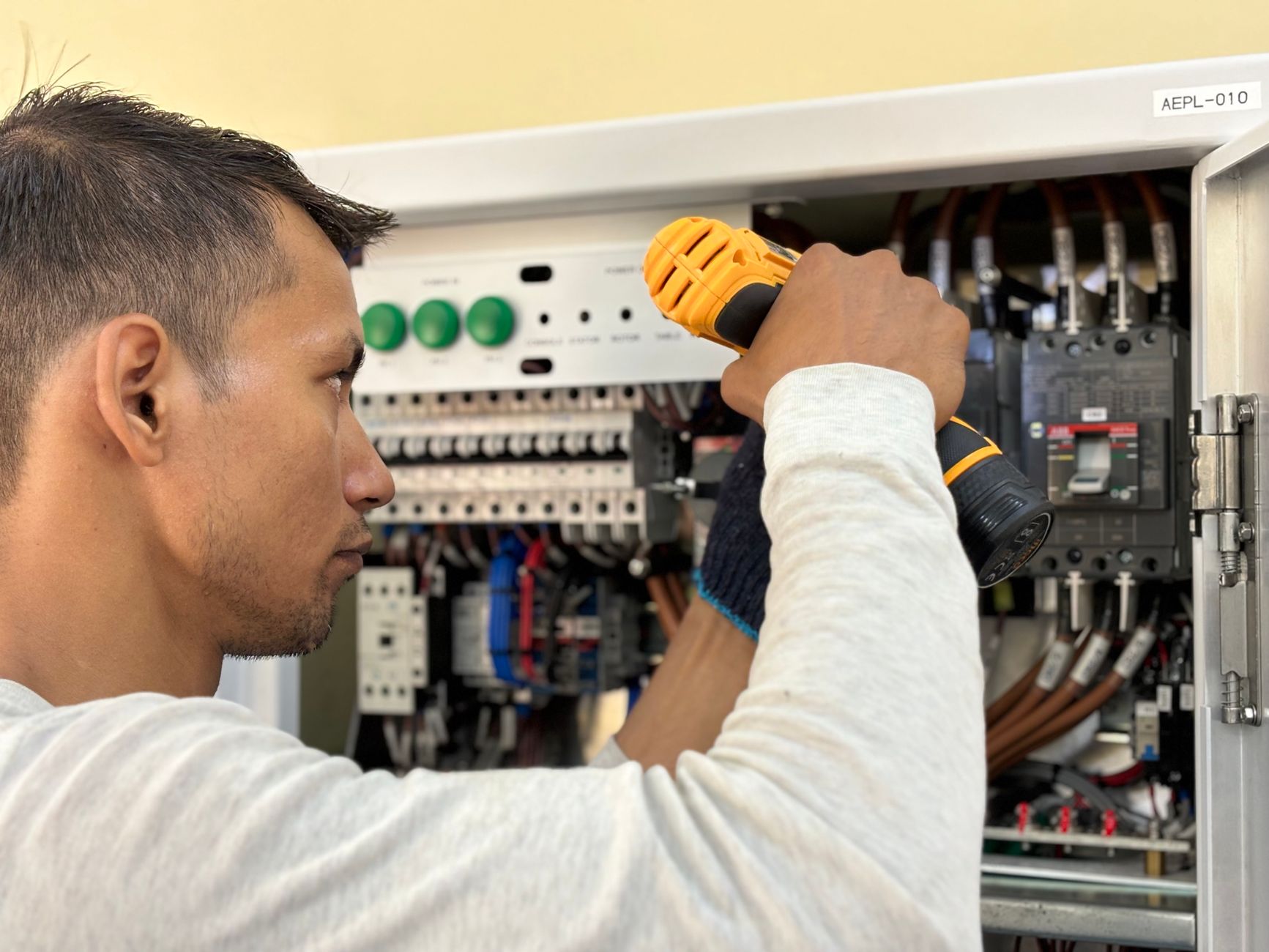 En elektriker arbetar med ett elskåp och installerar nya säkringar.